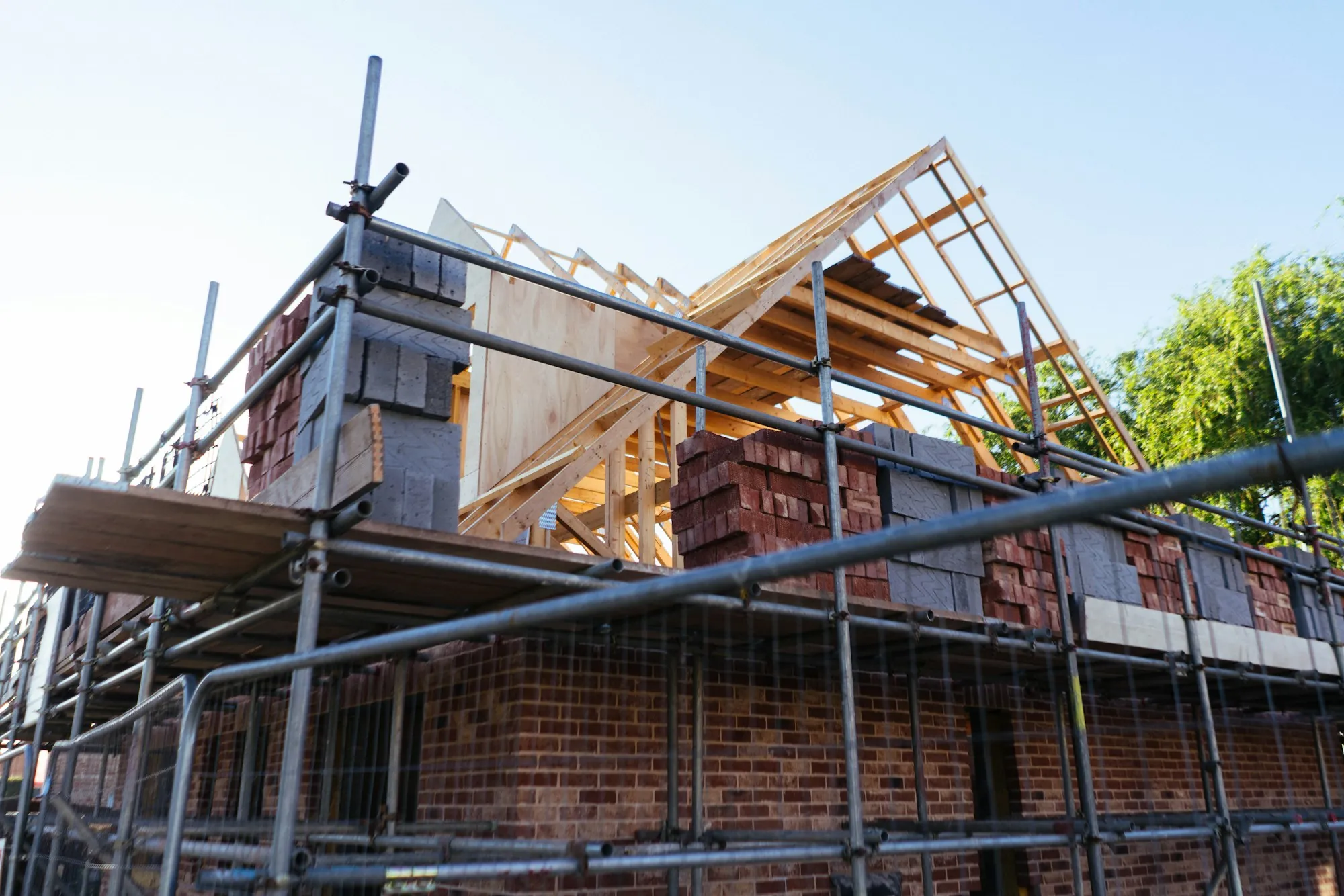 Scaffolding and new roof framing on a brick house