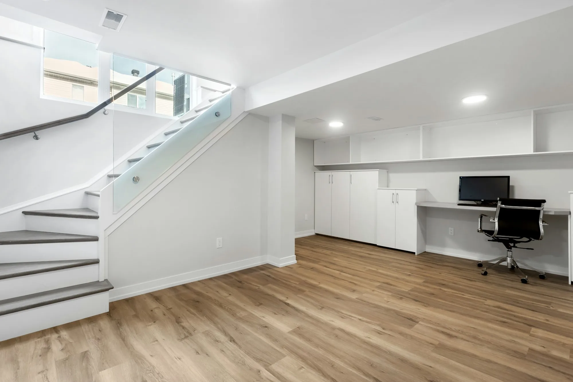 Finished basement with a staircase and built-in desk