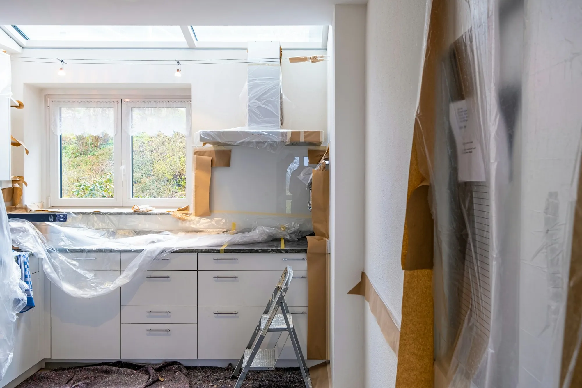 Kitchen counters and cabinets wrapped in protective plastic during work